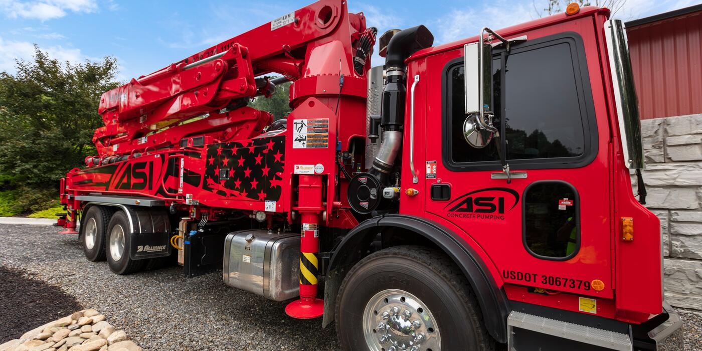 ASI boom pump truck with folded boom and flag graphics